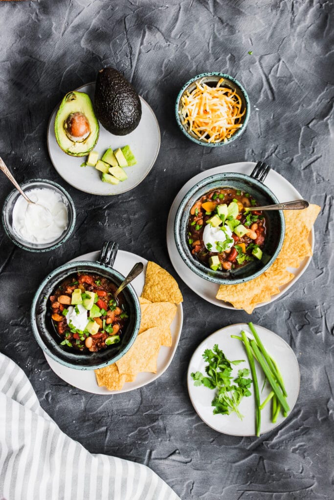 Two hearty bowls of healthy three bean beef chili with all of the toppings.