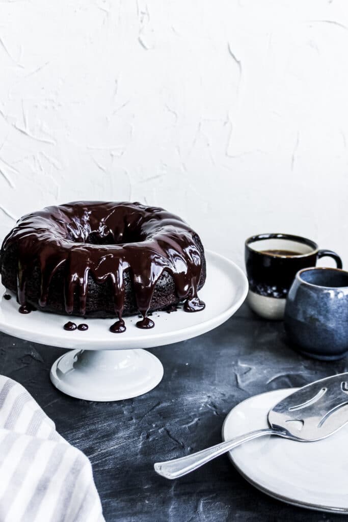 Frosted sourdough discard chocolate cake on a cake stand.