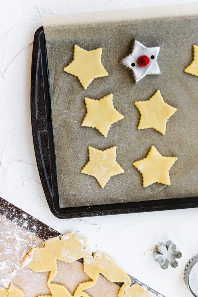 Star cut out sugar cookies on parchment paper.