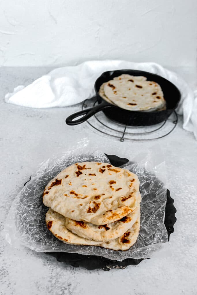 Stack of sourdough discard flatbreads arranged nicely on a round tray.