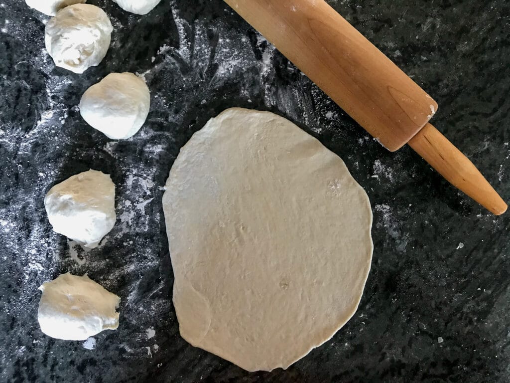 Showing the desired thinness when rolling the dough.