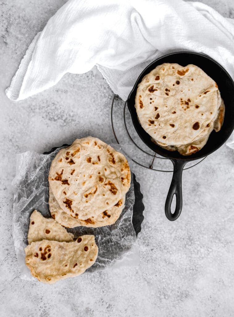 Looking down at sourdough discard flatbreads next to the cast iron pan.