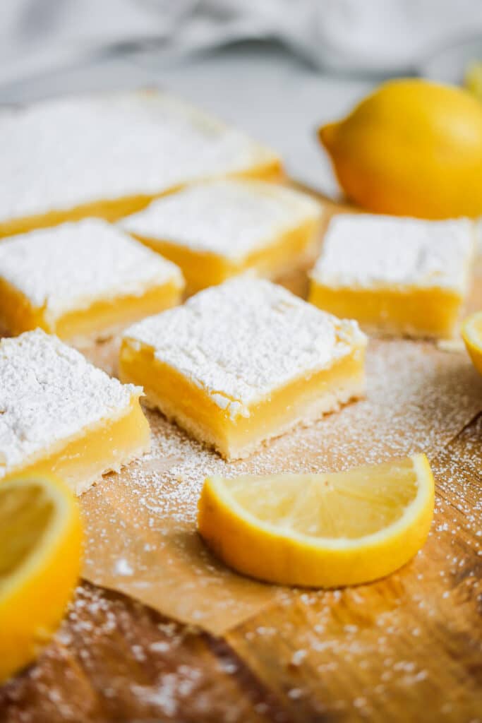 Lemon bars with powdered sugar and lemon slices.