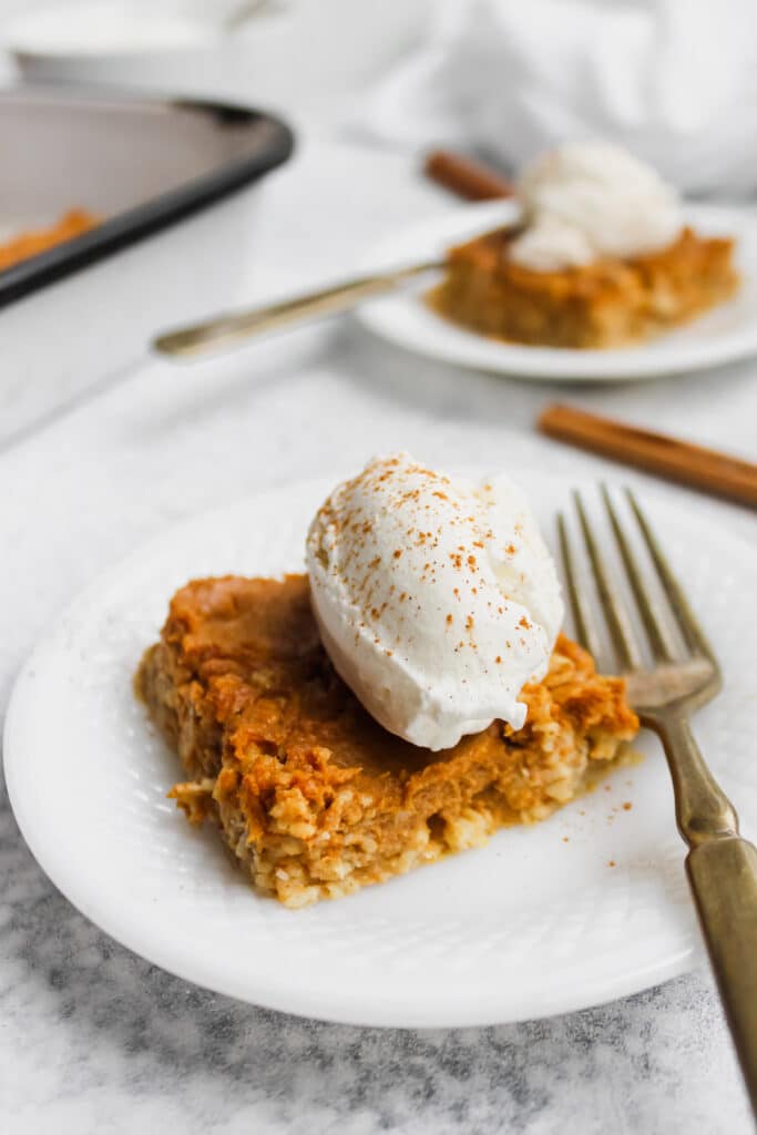 Close up of pumpkin pie baked oats with whipped cream and cinnamon.