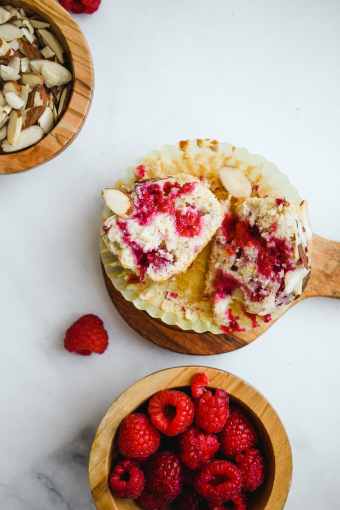 Raspberry almond muffin cut out and bursting with raspberries.