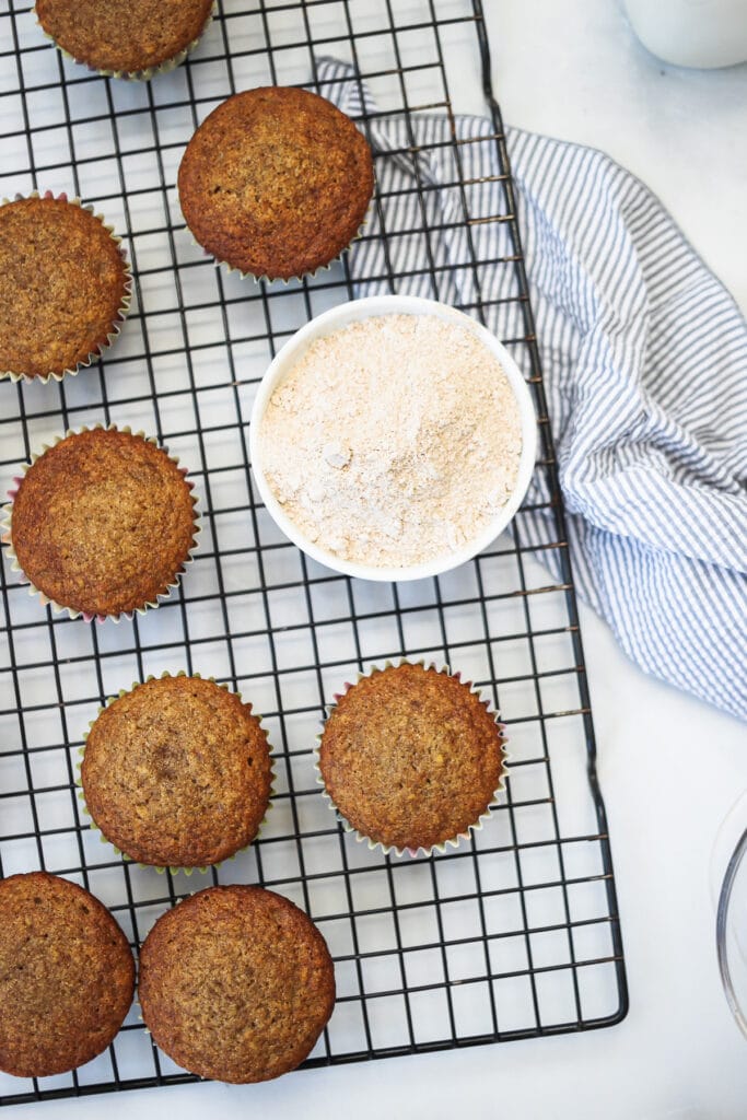 Baked whole wheat banana muffins on a cooling rack.