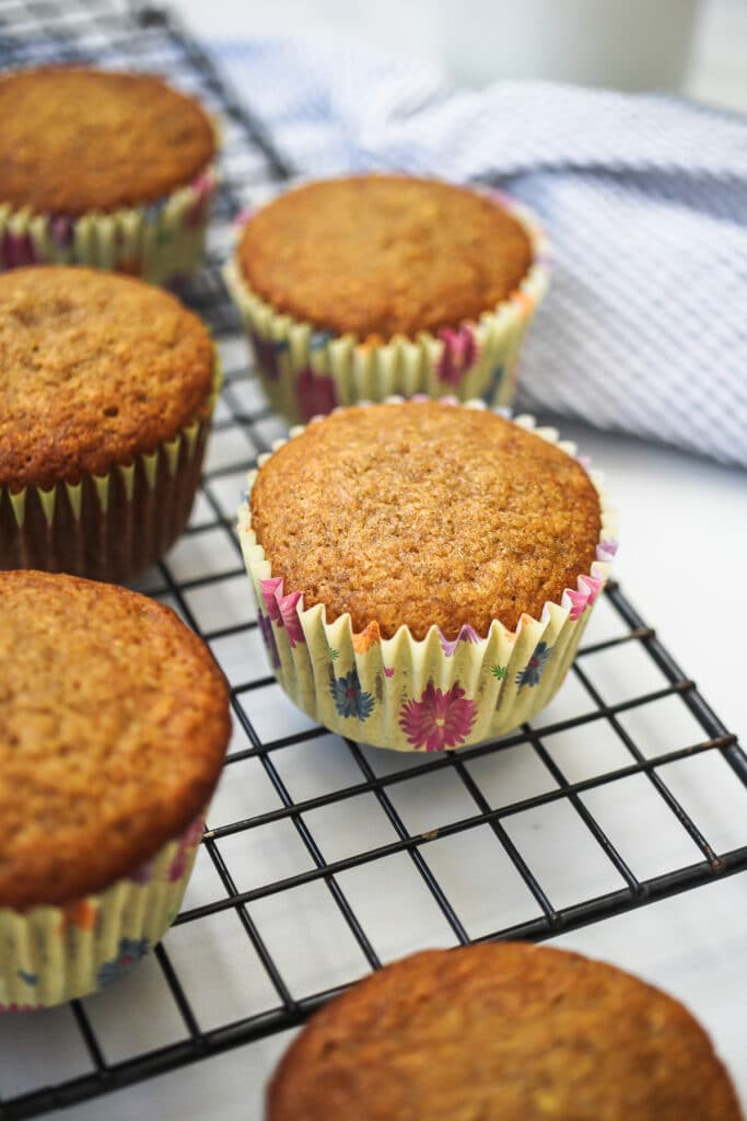 Close-up photo of the whole wheat banana muffins on a cooling rack.