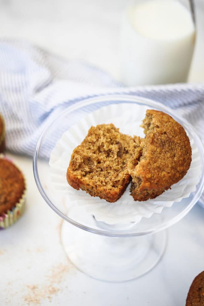 Whole wheat banana muffin cut in half with milk.