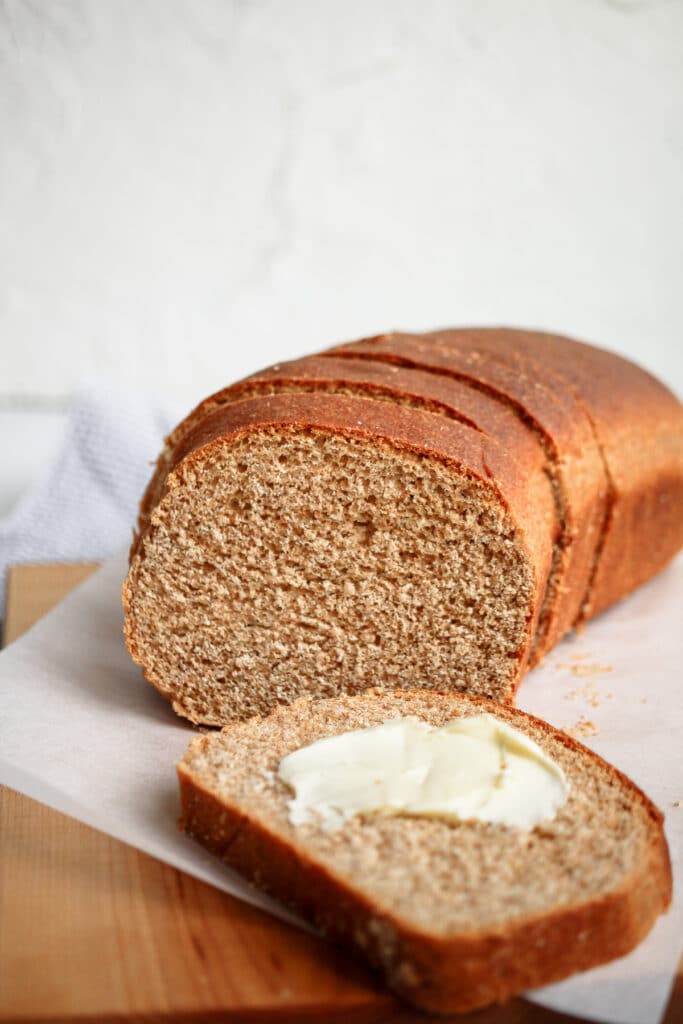 Loaf of honey whole wheat bread on a cutting board.