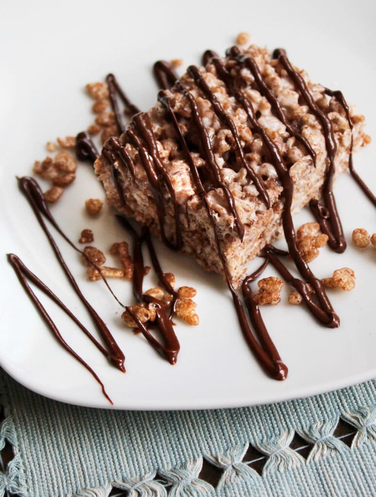 Chocolate krispie treat close up that is drizzled with chcoolate.