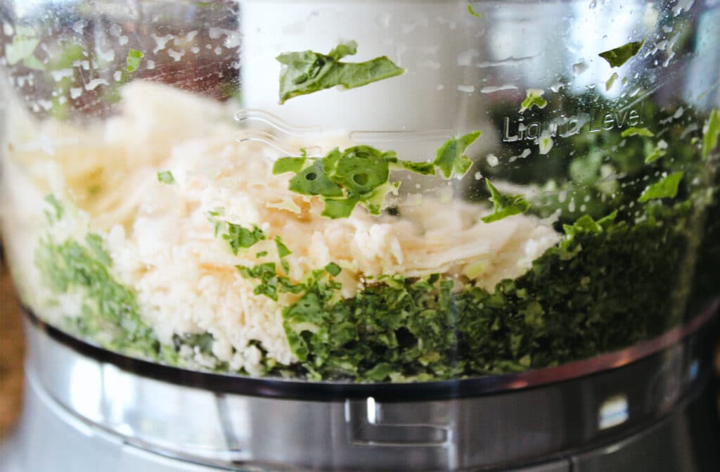 Ingredients for pesto being mixed in the food processor.