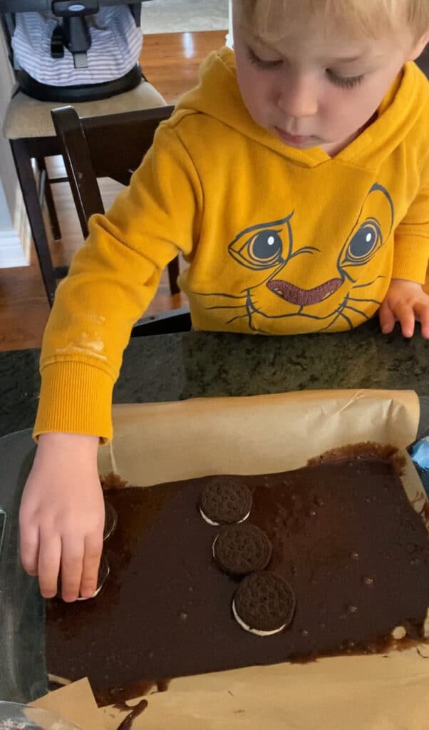 Mitchell helping arrange the cookies in the brownies.