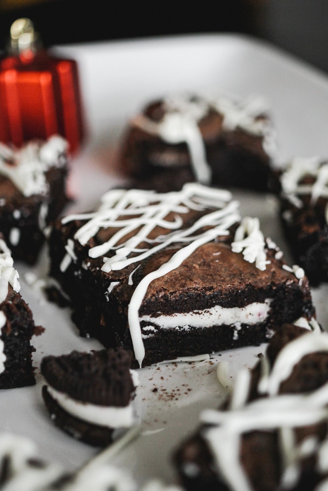 Close up of brownie with a peppermint oreo and drizzled with white chocolate.